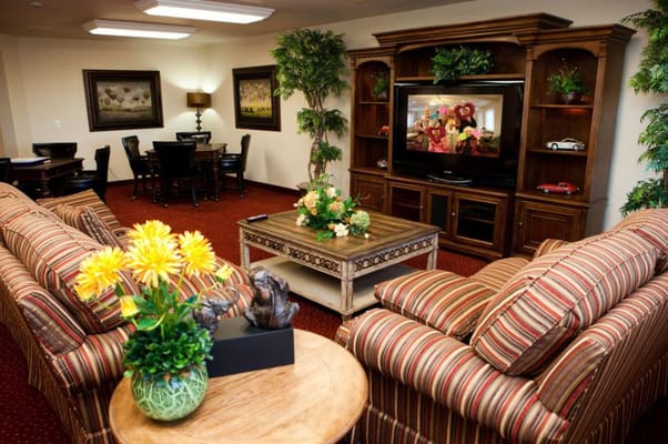 A cozy living room with plush sofas, a coffee table, and a large TV.