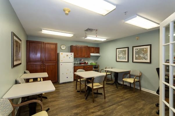 A spacious common area with tables and a kitchenette