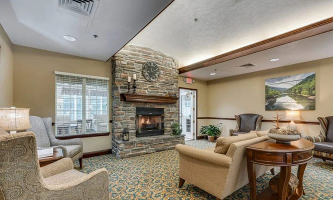 A cozy living room with a stone fireplace and plush seating.