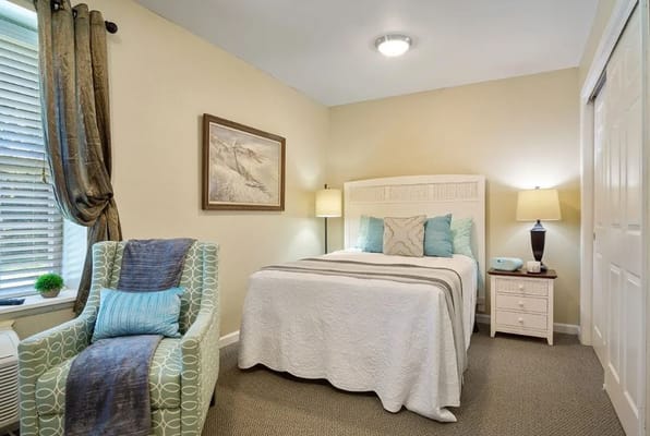 Bright and cozy bedroom with a bed, armchair, and decorative accents