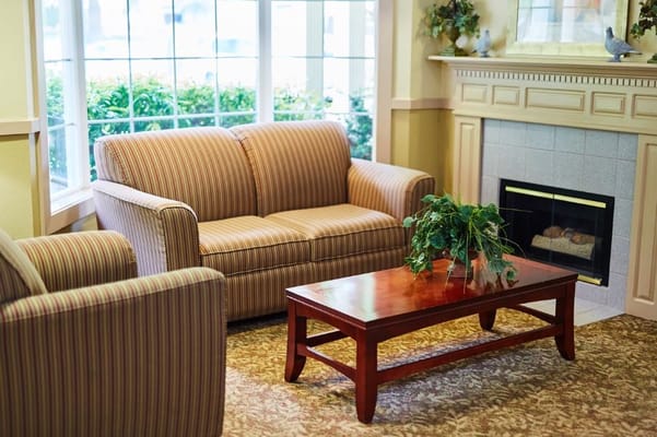 Comfortable seating area with a sofa, armchair, and coffee table in a well-lit room.