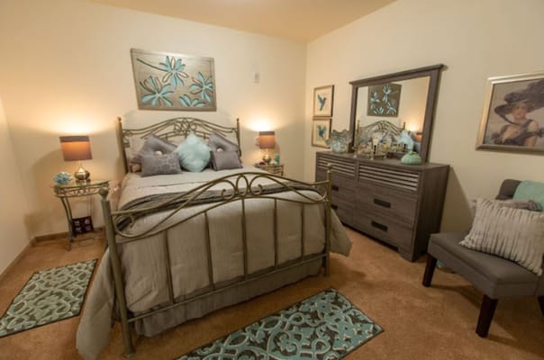 A well-decorated bedroom with a metal bed frame and neutral tones.