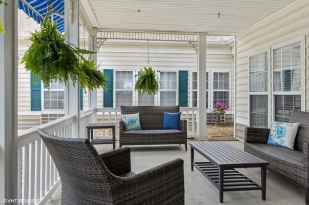 Outdoor seating area with lounge chairs and hanging plants