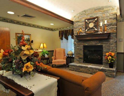A cozy living room with a stone fireplace and comfortable seating.