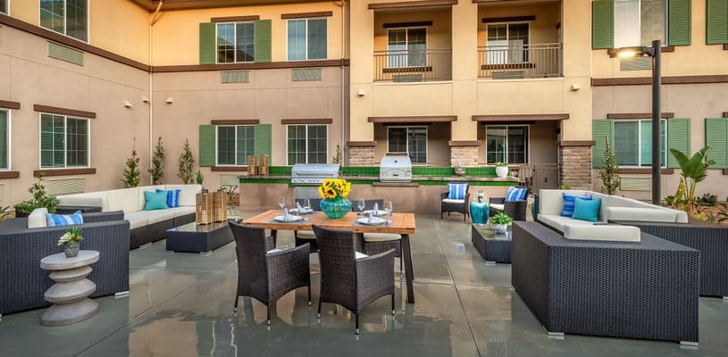 Stylish outdoor seating area with BBQ grill and greenery