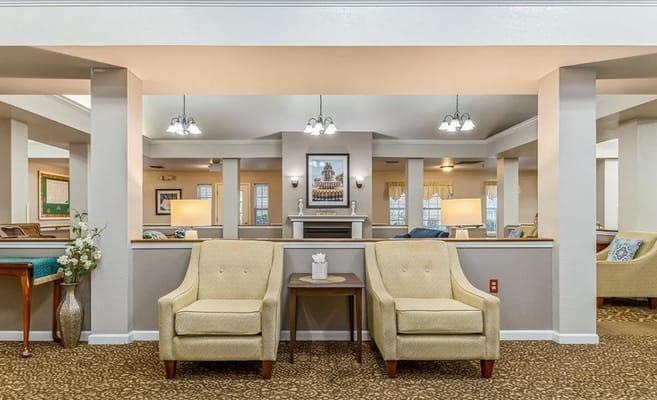 Two yellow armchairs facing a small table in a well-lit lobby