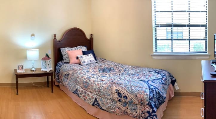 Cozy bedroom with a twin bed, lamp, and wooden furniture