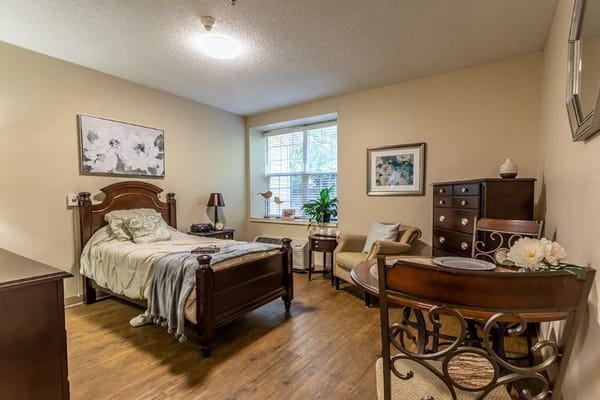 A cozy private resident room with a bed and seating area