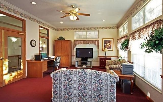 Comfortable living room with seating and TV in Riverbend facility