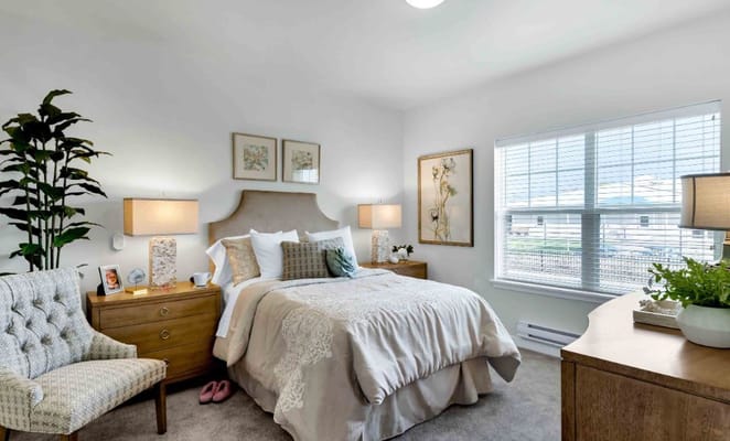 Brightly decorated bedroom with a bed, nightstands, and a cozy chair