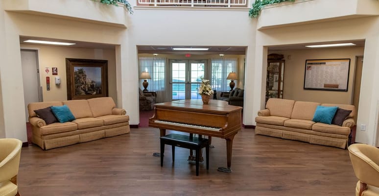 Cozy living room area featuring a piano and comfortable seating.