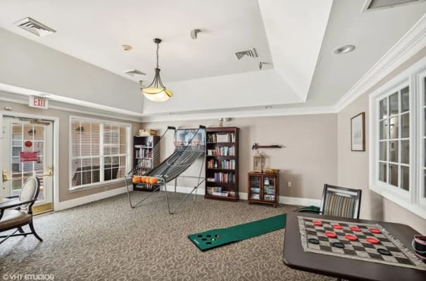 Cozy lounge area featuring seating, bookshelf, and games.
