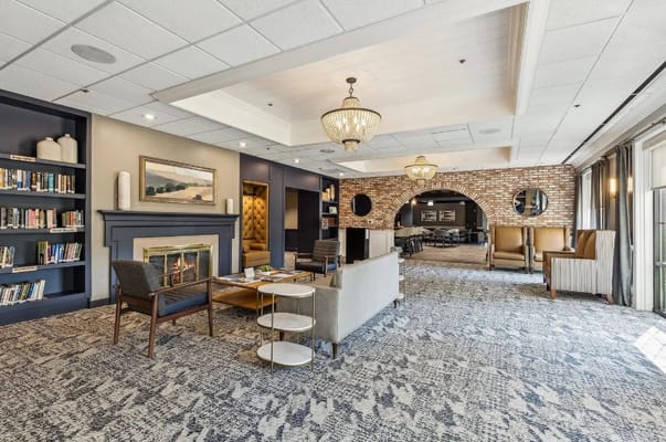 Spacious lounge with bookshelves, seating, and a fireplace