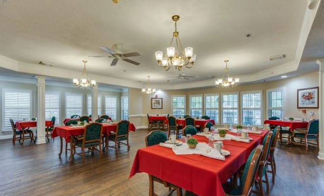 Dining area with red tablecloths and greenery decorations