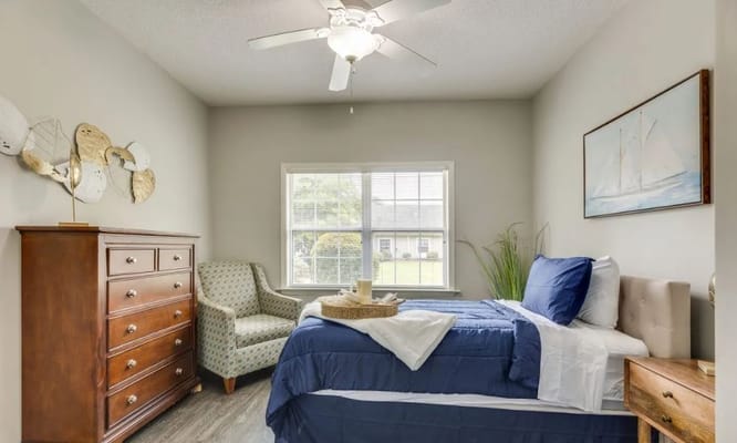 A well-decorated bedroom with a bed, dresser, and chair