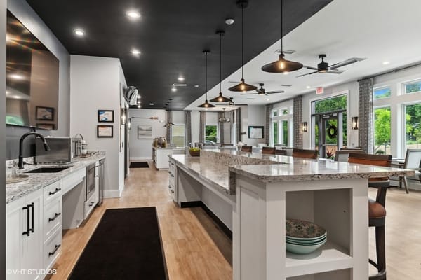 A modern kitchen area with granite countertops and seating.