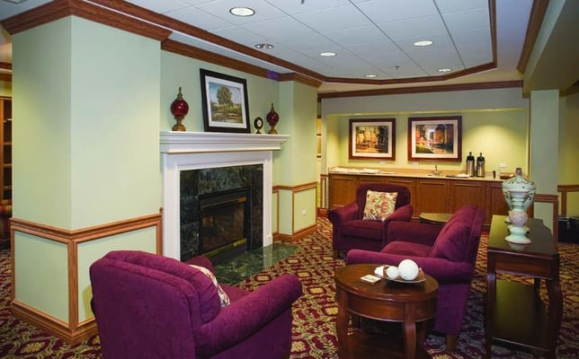 Inviting lounge area with purple chairs and a fireplace