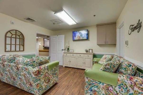 Colorful seating in a lounge area with a TV and a family-themed decor