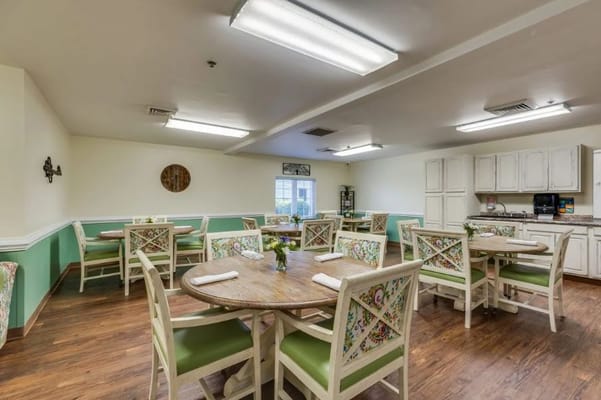 Bright and inviting dining room with wooden tables and decorative chairs.