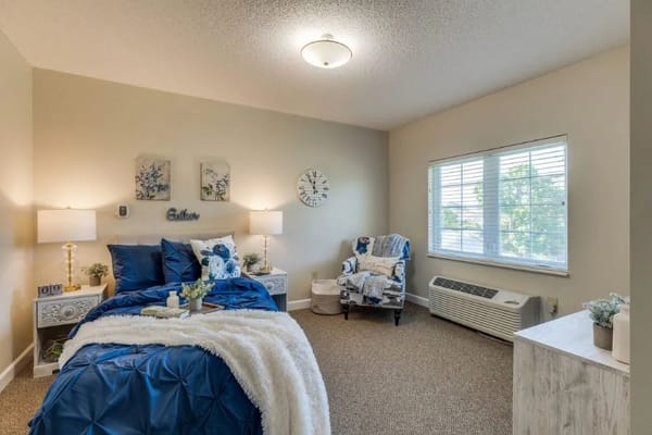 Cozy bedroom with blue bedding and decorative accents.