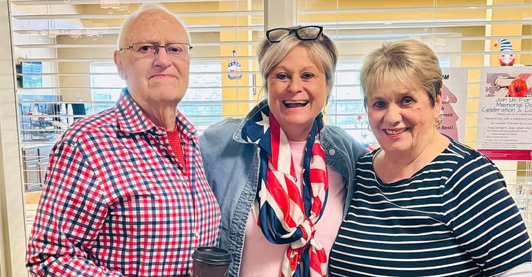 Residents and staff smiling together in a common area