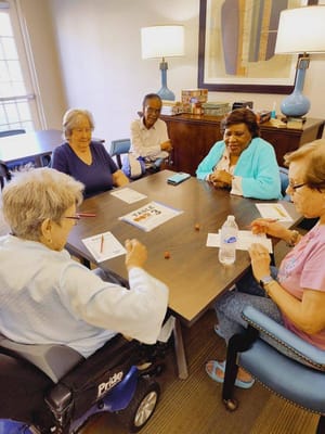 Residents playing a game around a table in a common area