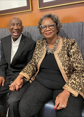 Two smiling residents enjoying time together in a common area