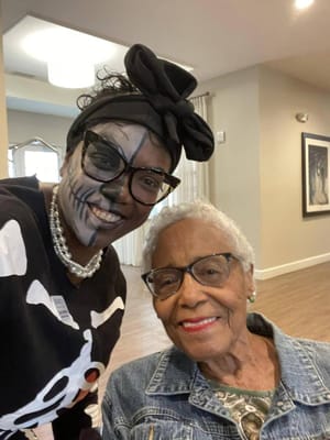 A resident and staff member celebrating in a common area