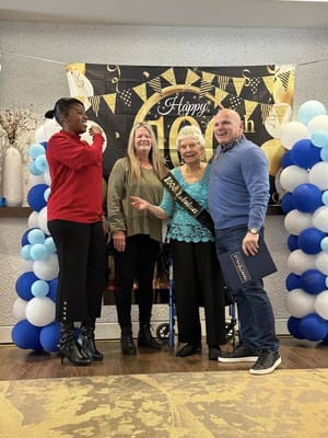Residents and staff celebrating a milestone event indoors