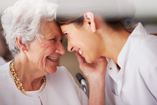 A nurse and a resident sharing a joyful moment
