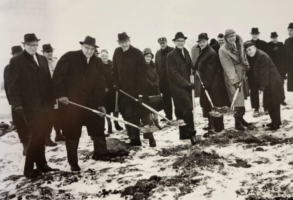 Group of people digging at a groundbreaking ceremony