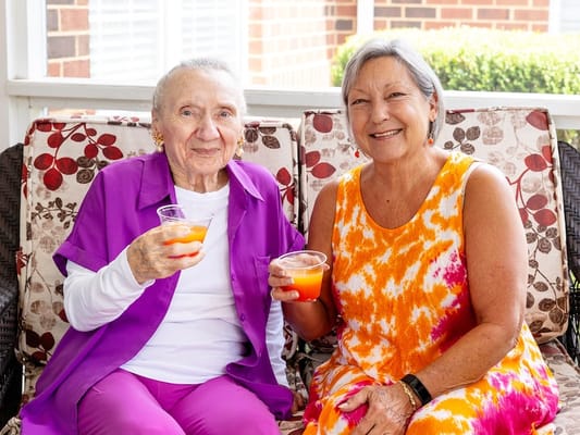 Residents enjoying drinks together on a cozy porch