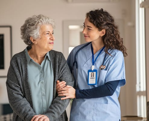 Healthcare worker assisting a resident in a cozy common area