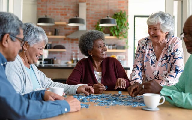 Residents engaged in a puzzle activity around a table