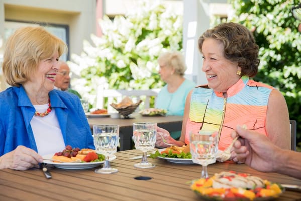 Two residents enjoying lunch outside on a sunny day