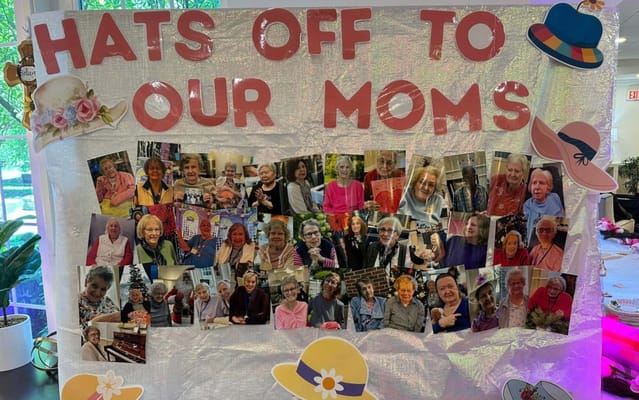 Residents celebrating Mother's Day with hats and photos