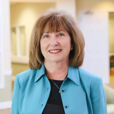 Staff member smiling in a well-lit interior space