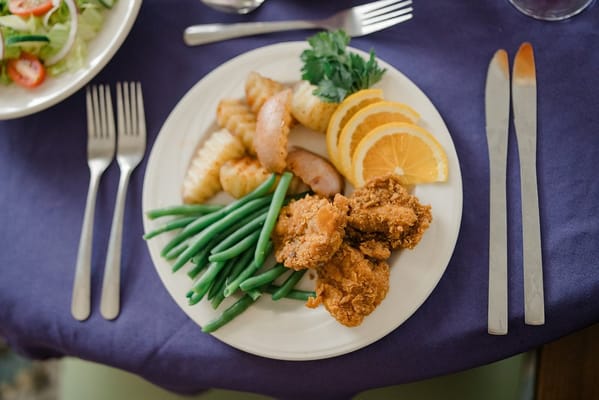 Plate of fried chicken, green beans, and oranges