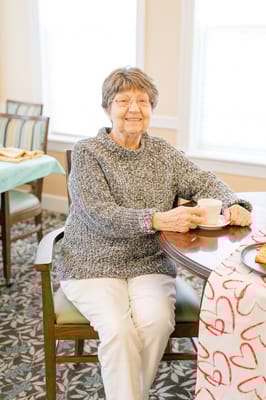 A senior woman enjoying tea in a common area