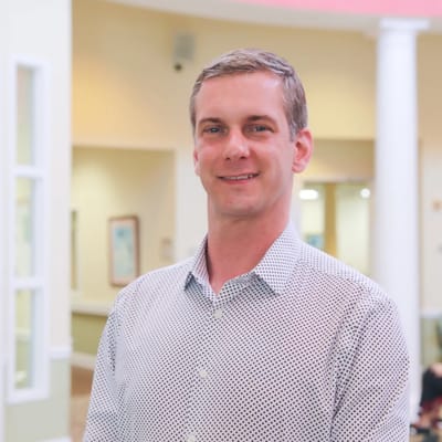 Man smiling in a bright facility lobby
