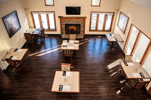 Dining area with tables and a fireplace in an interior setting