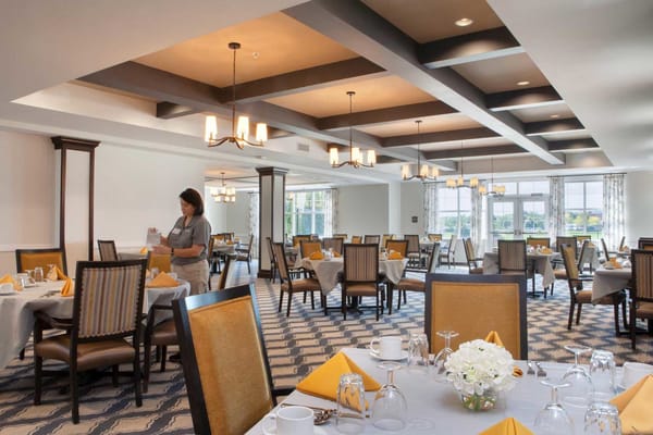 Dining room set for a meal with a staff member attending