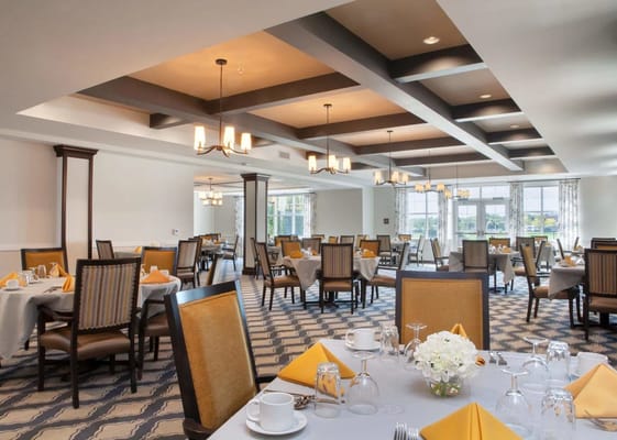 Elegant dining room setup with yellow accents and flower centerpiece