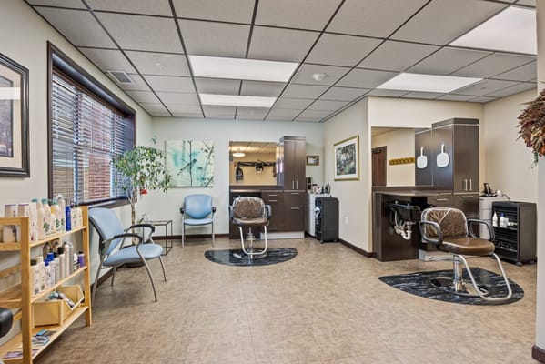 Bright hair salon area with styling chairs and equipment