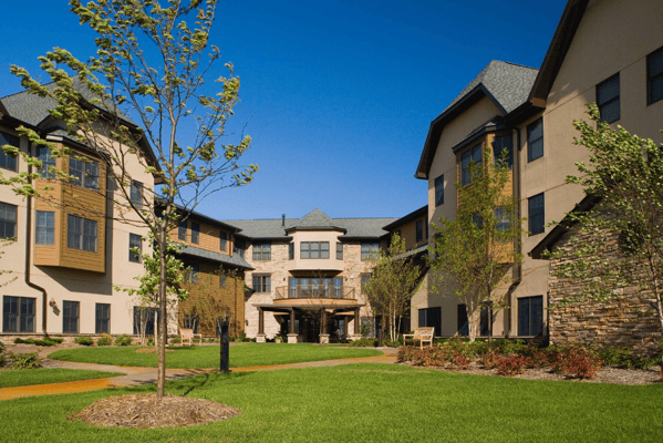 Exterior view of a senior living facility with landscaped gardens