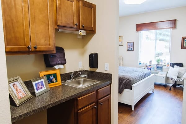View of a resident room with kitchenette and bed
