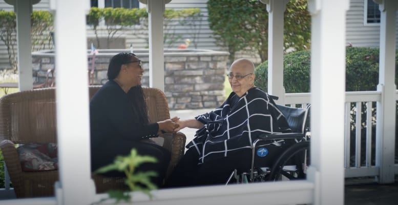Resident and staff member enjoying conversation outdoors