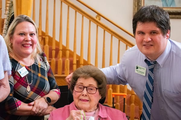 Residents and staff posing together in a common area