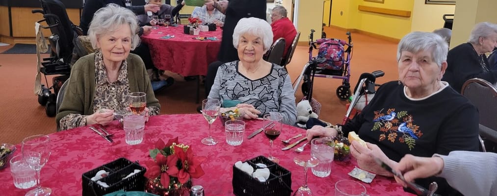 Three residents enjoying a meal in a dining area