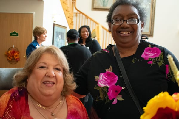 Two residents smiling together in a common area